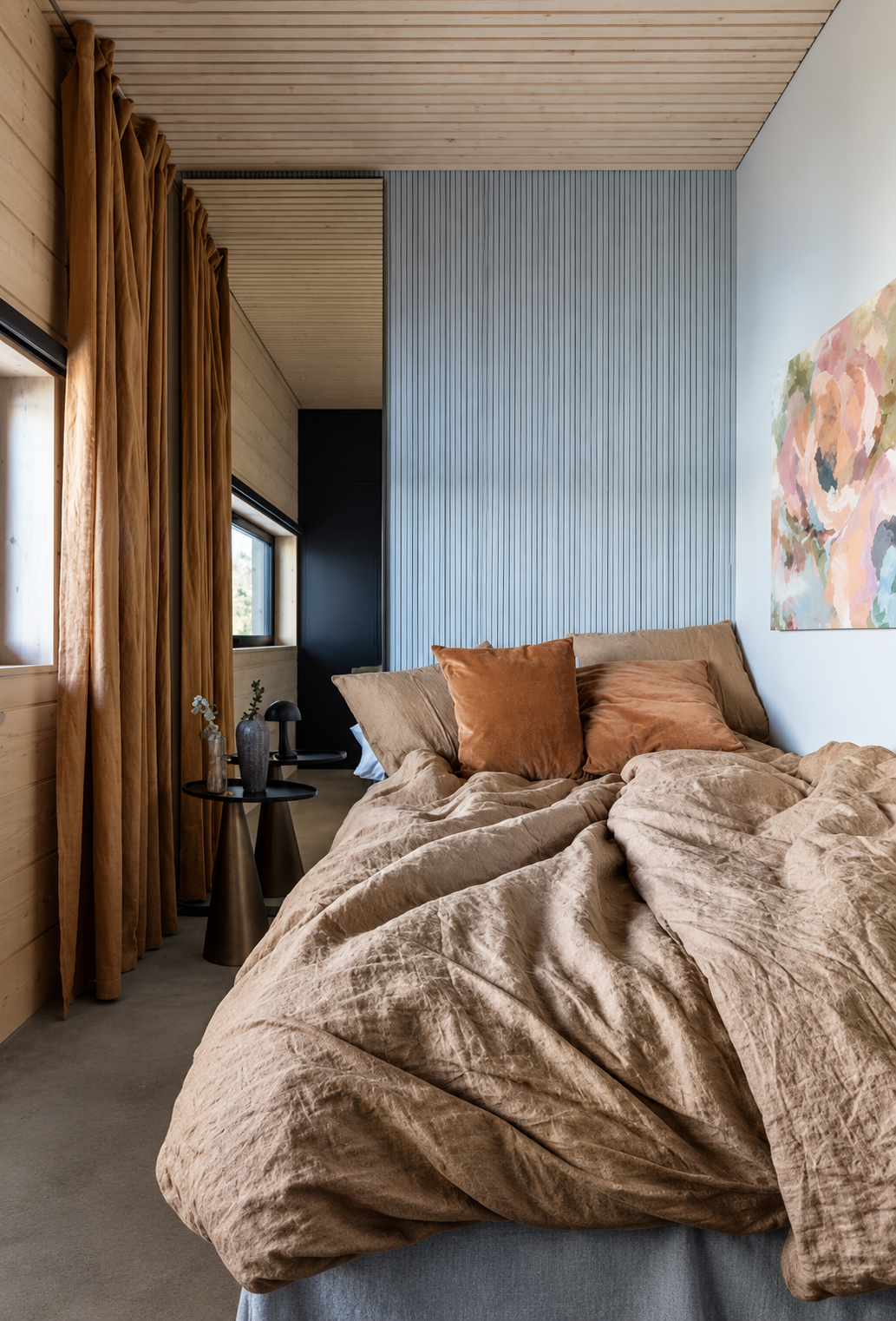 Bedroom with warm rust-toned linen, a slatted grey headboard wall and a soft floral artwork