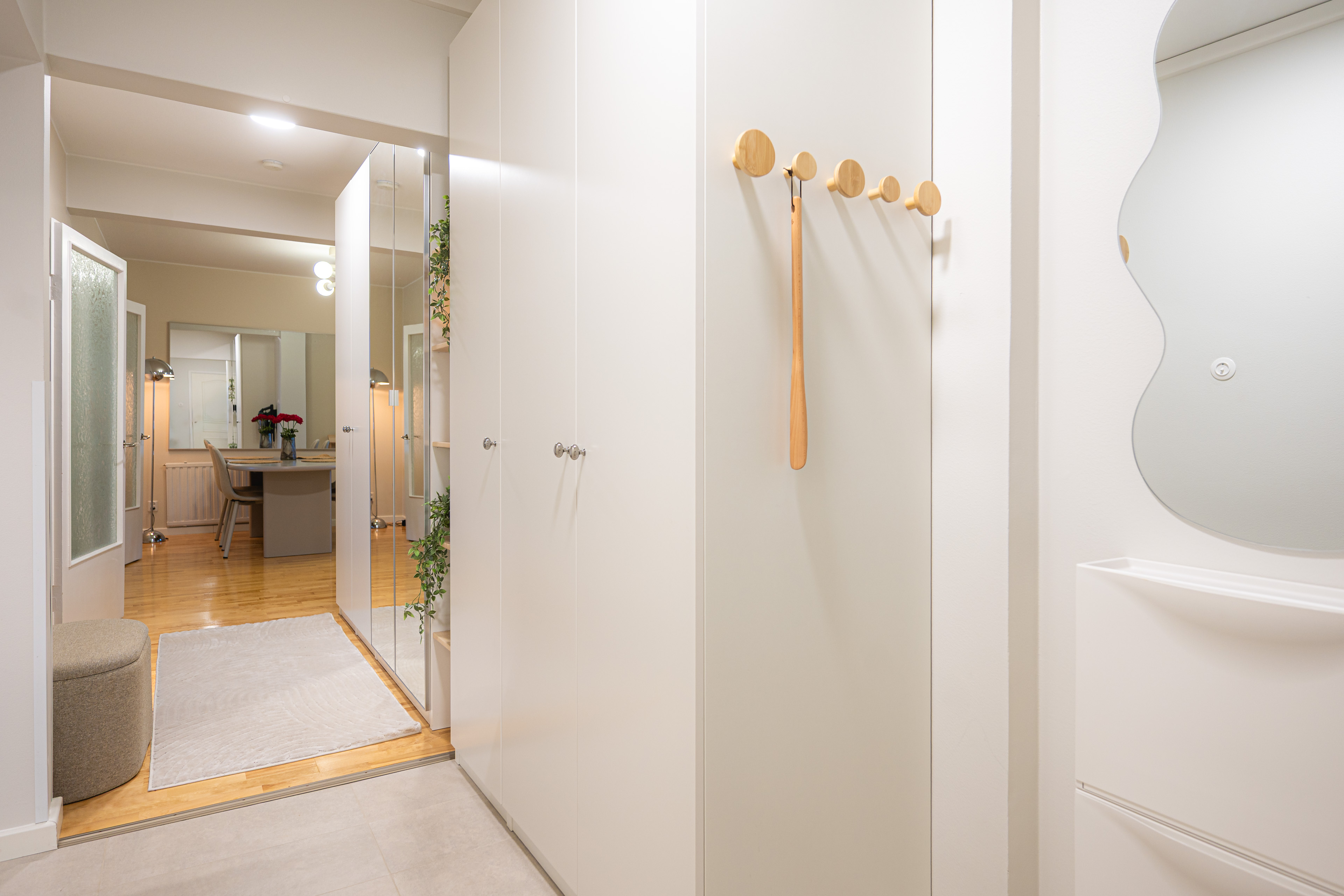 Hallway in whites and light wood with a view through to the dining area