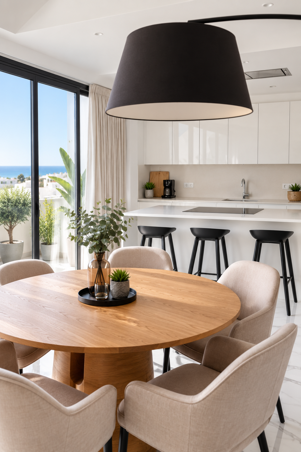 Round oak dining table beside the white kitchen with Mediterranean views at The View Fuengirola