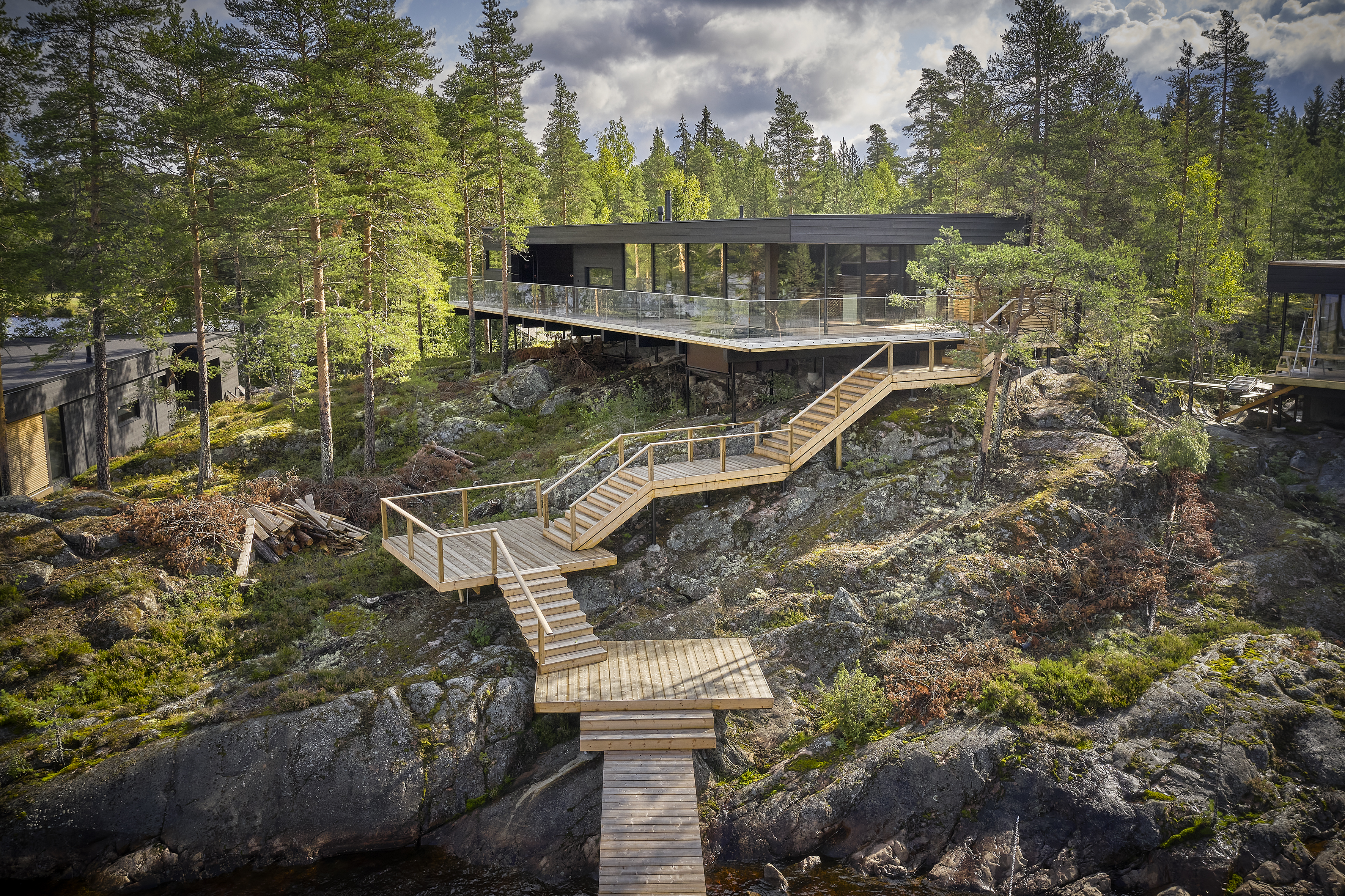 Aerial view of the villa and its wooden stairways descending the rocky slope towards the water