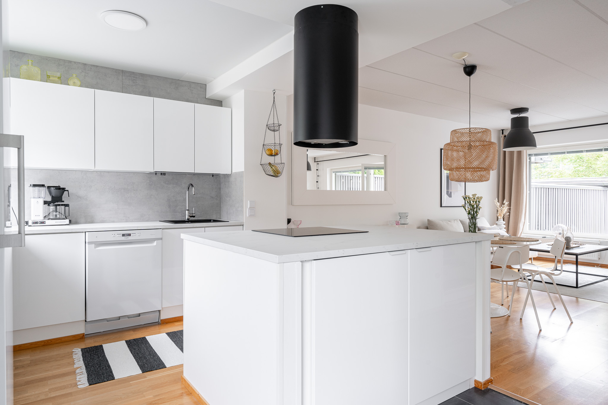 White kitchen with a large island, oak floor and a striped runner