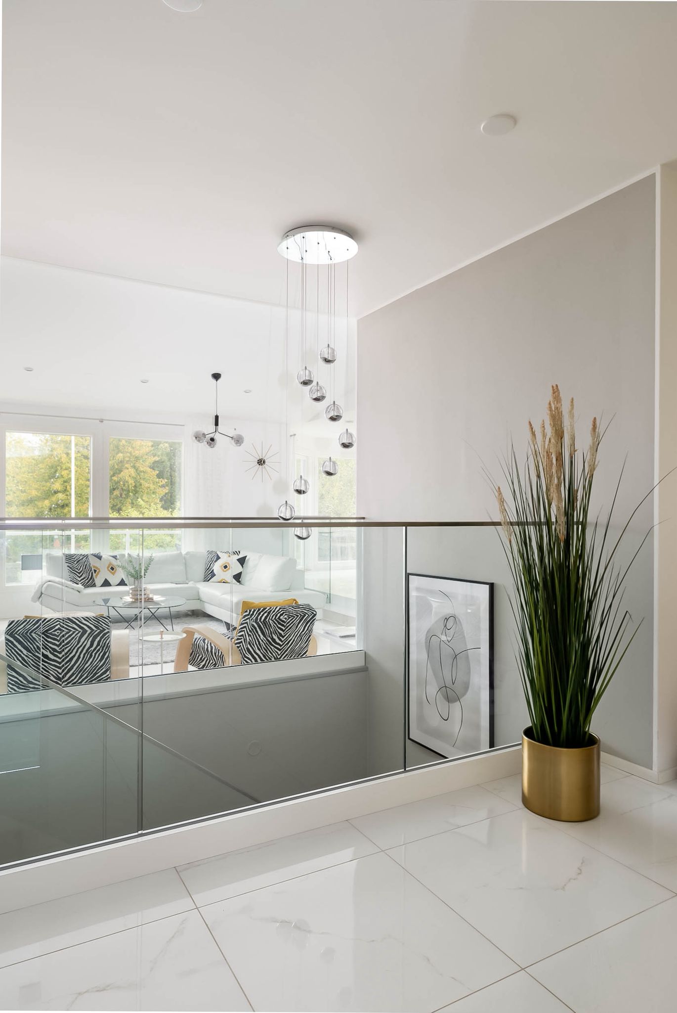 Stairway with a glass balustrade and a view down to the living room