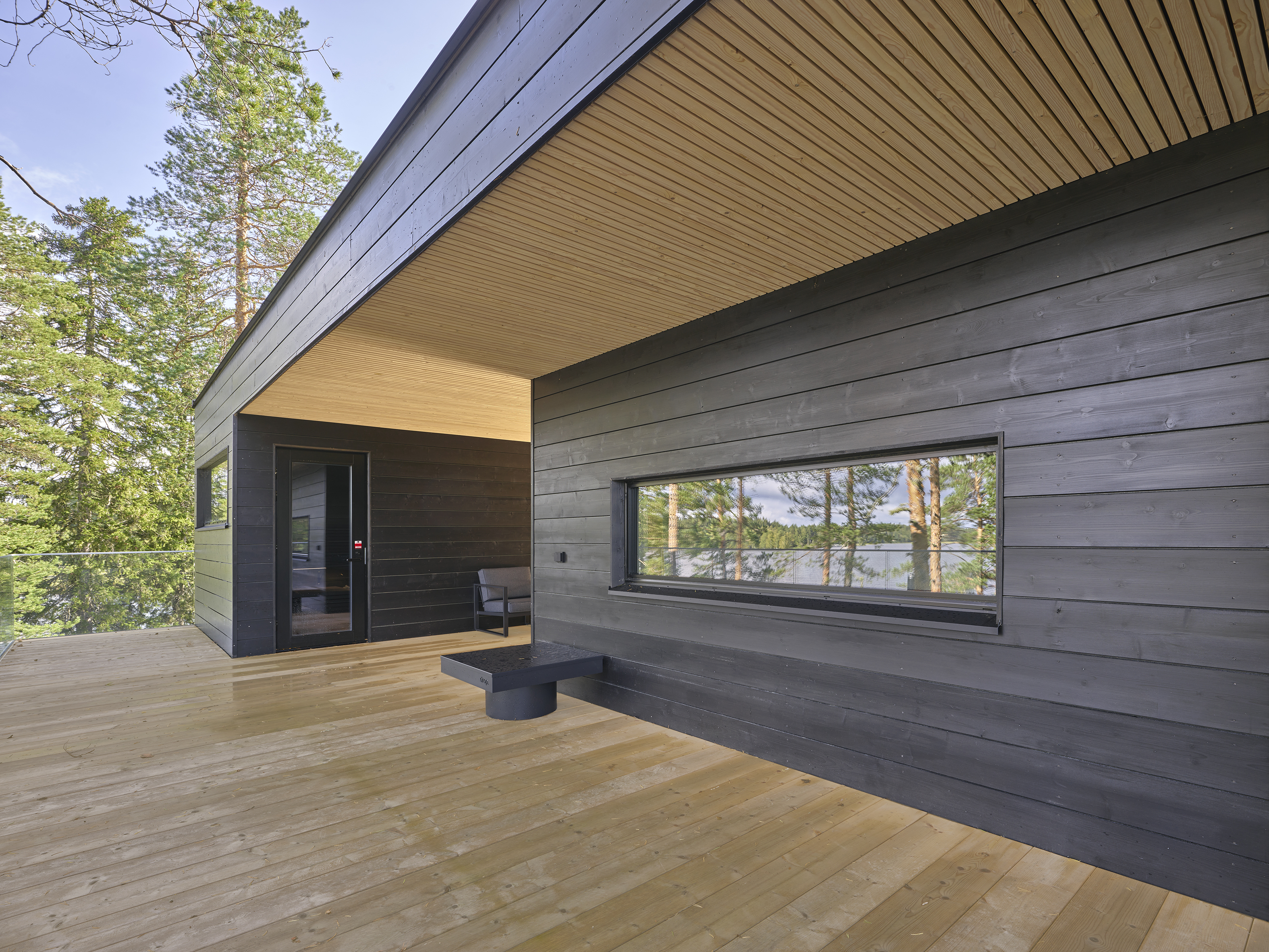 Covered terrace corner with black timber cladding and a narrow horizontal window