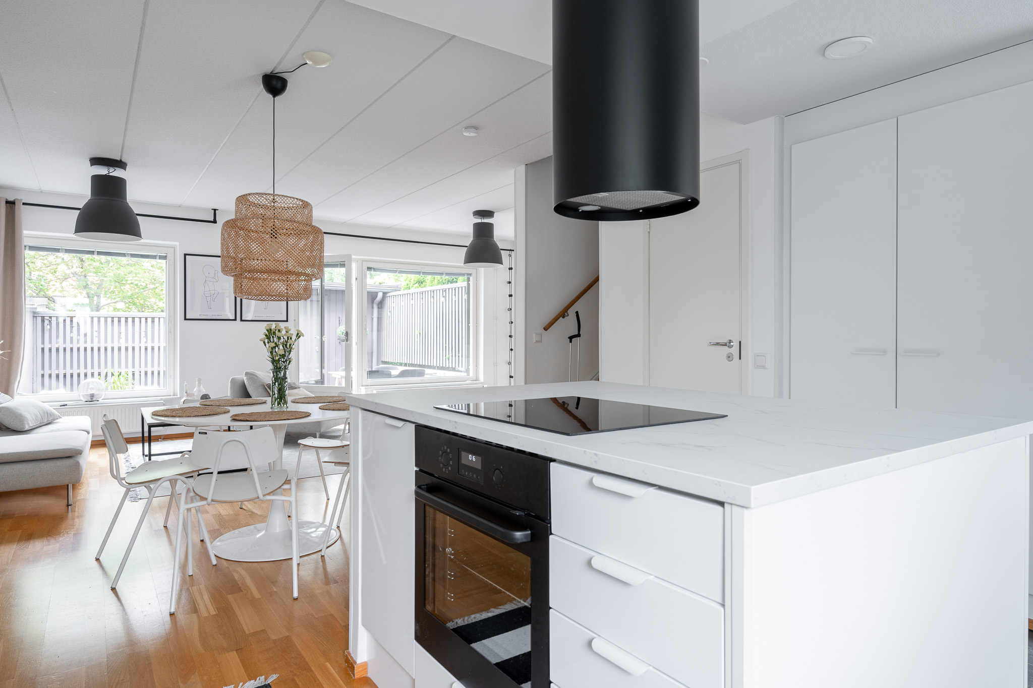 Kitchen island with a black extractor, oak floor and a view through to the dining area